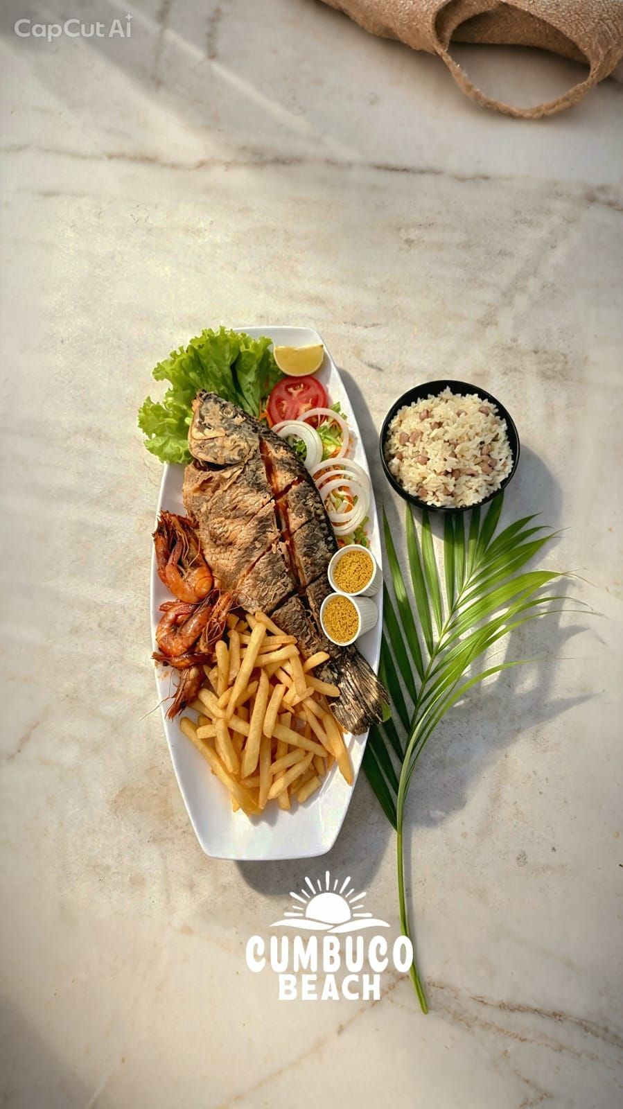 Peixe frito com batatas, salada e arroz servido na Barraca Cumbuco Beach
